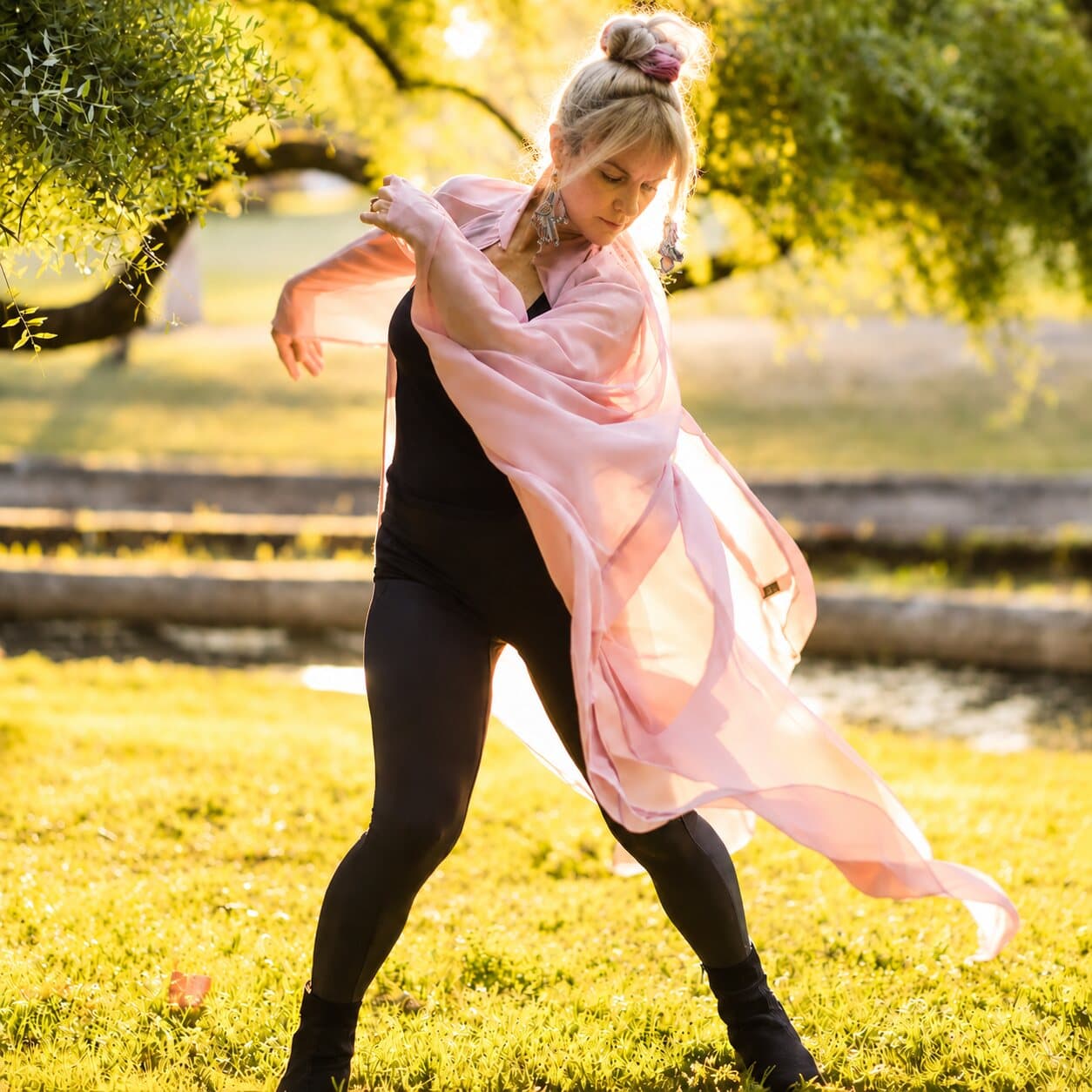 The starting photograph: a dancer mid-turn on sunlit grass, a pink wrap trailing behind her